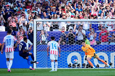 France's Kylian Mbappe (10) scores his side's opening goal from the penalty spot during the World Cup round of 16 soccer match against Paraguay in Philadelphia