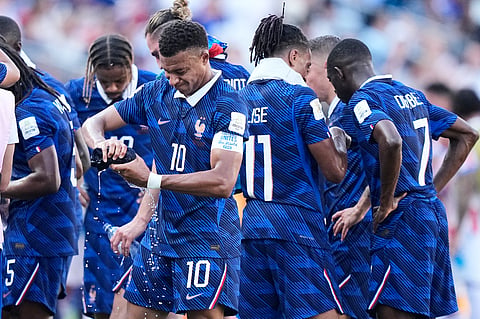 France's Kylian Mbappe (10) wrings out a towel during a hydration break in the World Cup round of 16 soccer match between Paraguay and France in Philadelphia