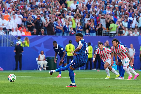 France's Kylian Mbappe (10) scores from a penalty kick the opening goal during the World Cup round of 16 soccer match between Paraguay and France in Philadelphia,