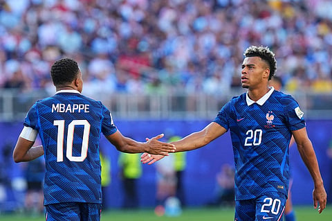 France's Desire Doue (20) shakes hands with France's Kylian Mbappe (10)during the World Cup round of 16 soccer match between Paraguay and France in Philadelphi
