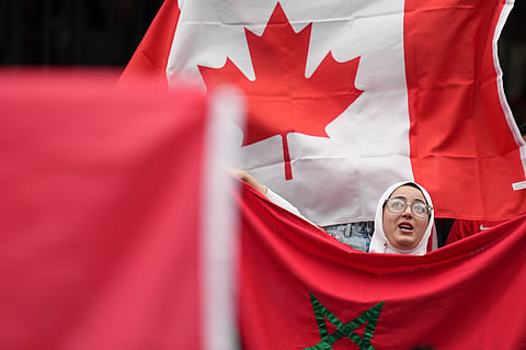 A fan holds a flag of Morocco prior to the World Cup round of 16 soccer match between Canada and Morocco in Houston