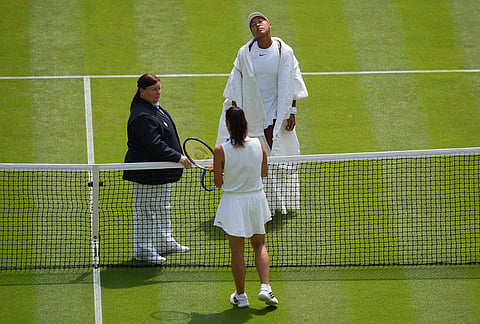 Naomi Osaka of Japan, top, stretches her neck in front of her opponent Daria Kasatkina of Australia ahead of their third round women's singles match at the Wimbledon Tennis Championships in London, Friday, July 3, 2026. 
