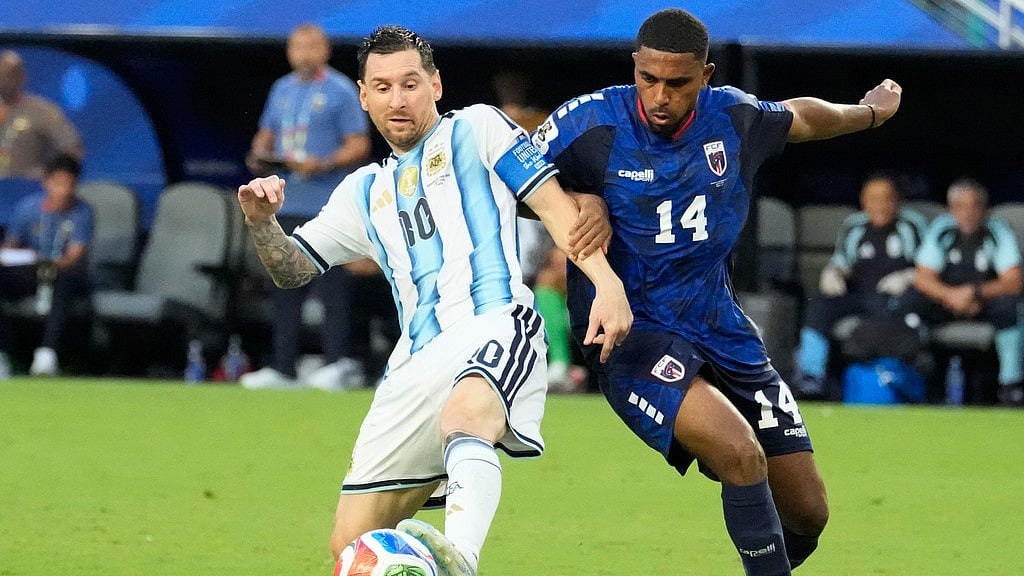 Argentina's Lionel Messi (10) controls the ball while defended by Cape Verde's Deroy Duarte (14) during the World Cup round of 32 soccer match between Argentina and Cape Verde in Miami Gardens. - Chris Carlson/AP Photo