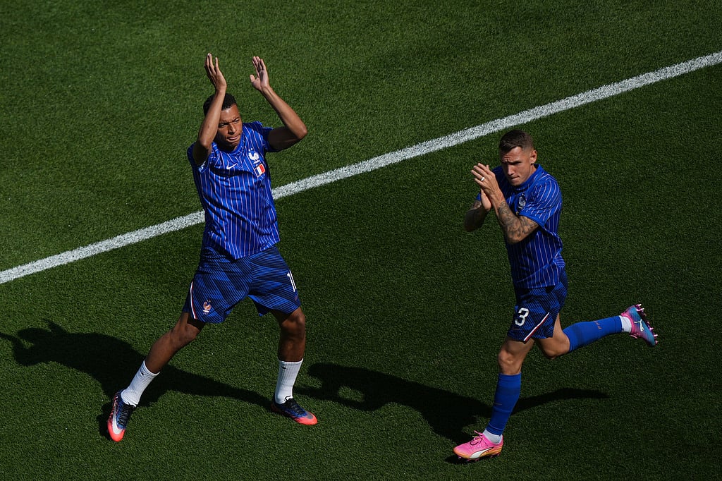 France's Kylian Mbappe, left, and France's Lucas Digne wave to fans during the warm up before the World Cup round of 16 soccer match against Paraguay in Philadelphia. - Matt Rourke/AP Photo