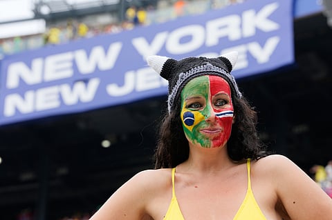 A fan with their face painted in the flags of Brazil and Norway waits for the start of the World Cup round of 16 soccer match between Brazil and Norway