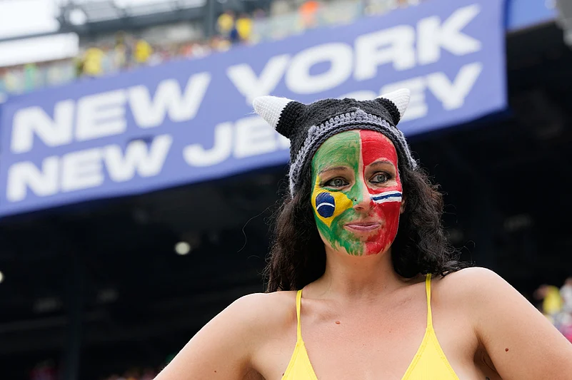 A fan with their face painted in the flags of Brazil and Norway waits for the start of the World Cup round of 16 soccer match between Brazil and Norway