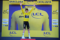 Tour de France 2026: Jonas Vingegaard Wins Stage 1, Claims First Yellow Jersey In Barcelona | Photo: AP/Thibault Camus : Denmark's Jonas Vingegaard celebrates on the podium after wining the first stage of the Tour de France cycling race, a team time-trial over 19.6 kilometers (11.8 miles) with start and finish in Barcelona, Spain.