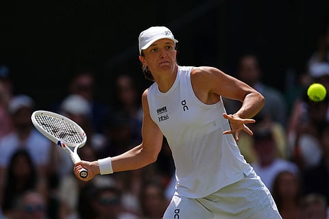 Iga Swiatek of Poland plays a return during the third round women's singles match against Alexandra Eala of the Philippines at the Wimbledon Tennis Championships in London.