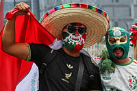 AP : Mexico soccer fans wearing Lucha Libre wrestling masks arrive for a watch party near the Angel of Independence monument before the start of the World Cup soccer match between Mexico and England, in Mexico City