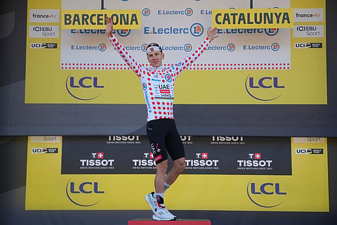 Slovenia's Tadej Pogacar celebrates on the podium with the best climber's dotted jersey after the first stage of the Tour de France cycling race, a team time-trial over 19.6 kilometers (11.8 miles) with start and finish in Barcelona, Spain.