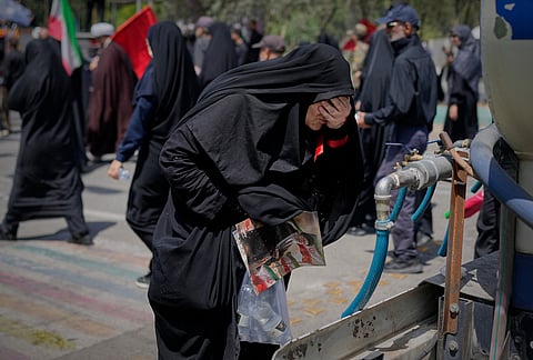 A mourner cools herself with water outside the Imam Khomeini Mosalla Grand Mosque during the funeral ceremonies for the late Iranian Supreme Leader Ayatollah Ali Khamenei and members of his family in Tehran, Iran, Saturday, July 4, 2026. 