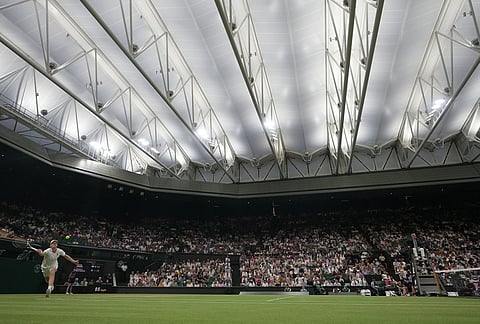 Jannik Sinner of Italy returns the ball to Shintaro Mochizuki of Japan in their fourth round men's singles match at the Wimbledon Tennis Championships in London, Sunday, July 5, 2026. 