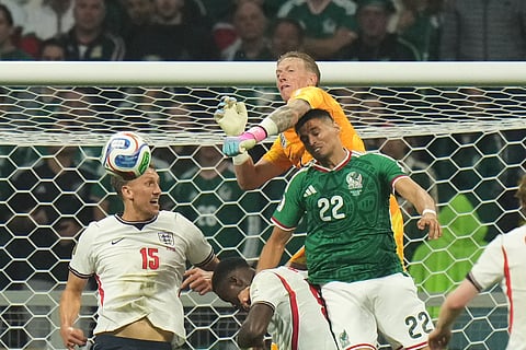 England goalkeeper Jordan Pickford (1) punches the ball clear of Mexico's Guillermo Martinez (22) during the World Cup round of 16 soccer match between Mexico and England in Mexico City, Sunday, July 5, 2026