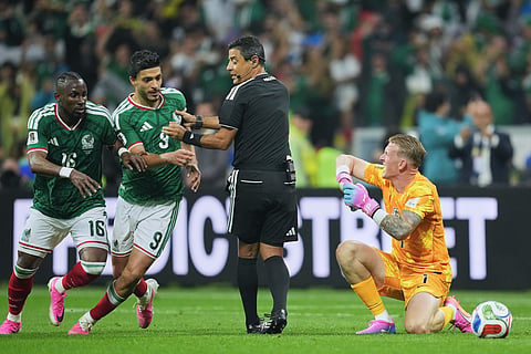 Referee Alireza Faghani, center, looks on as England goalkeeper Jordan Pickford (1) and Mexico's Julian Quinones (16) and Raul Jimenez (9) react during the World Cup round of 16 soccer match between Mexico and England in Mexico City, Sunday, July 5, 2026