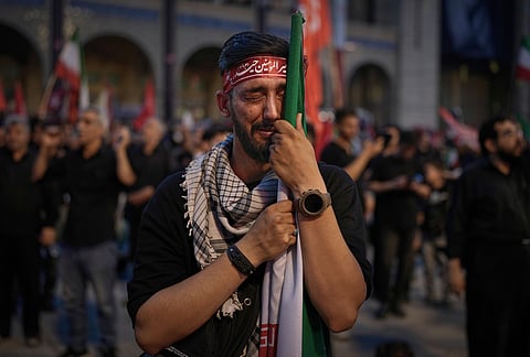 A man weeps during funeral ceremonies for slain Iranian Supreme Leader Ayatollah Ali Khamenei and members of his family at the Imam Khomeini Mosalla Grand Mosque in Tehran, Iran, Sunday, July 5, 2026.