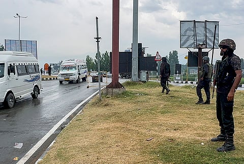 Security personnel stand guard along the Jammu-Srinagar National Highway as Amarnath Yatra pilgrims proceed towards the Pahalgam base camp amid rainfall, in Anantnag district, Jammu and Kashmir.