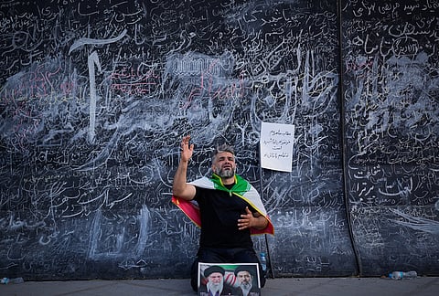 A man mourns while kneeling with a picture of both Iran's new Supreme Leader, Mojtaba Khamenei, right, and Iran's slain Supreme Leader Ayatollah Ali Khamenei during funeral ceremonies at the Imam Khomeini Mosalla Grand Mosque in Tehran, Iran, Sunday, July 5, 2026.