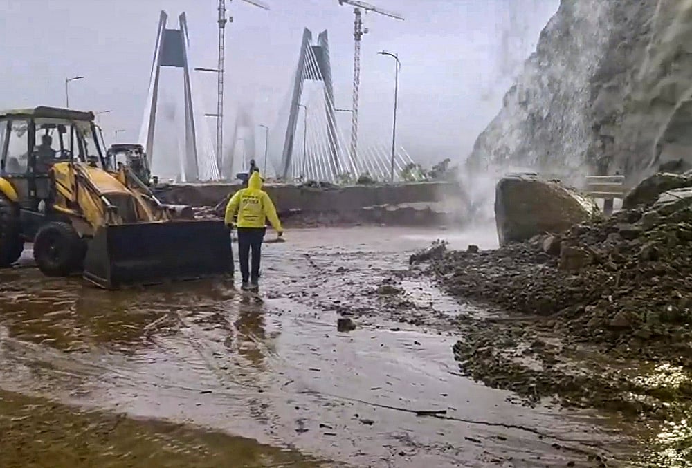 Restoration work underway after debris and boulders partially cover a portion of the Pune to Mumbai carriageway of the Khopoli-Kusgaon ‘Missing Link’ near the exit of Tunnel 2 following landslide amid heavy monsoon rains, in Pune district, Maharashtra. - | Photo: PTI