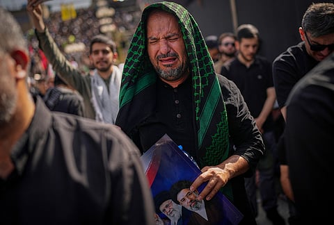 A mourner weeps as he attends the start of the dayslong funeral ceremonies for the late Iranian Supreme Leader Ayatollah Ali Khamenei and members of his family at the Imam Khomeini Mosalla Grand Mosque in Tehran, Iran, Saturday, July 4, 2026. 