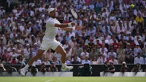 Photo: AP/Brian Inganga : Novak Djokovic of Serbia returns the ball to Roman Saffiulin of Russia in their fourth round mens singles match at the Wimbledon Tennis Championships in London.