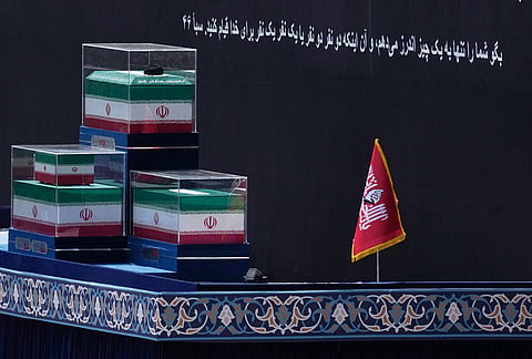 The coffins of the late Iranian Supreme Leader Ayatollah Ali Khamenei and members of his family are displayed on a platform before the start of the dayslong funeral ceremonies at the Imam Khomeini Mosalla Grand Mosque in Tehran, Iran, Saturday, July 4, 2026. A Quran verse in Persian on the backdrop reads, "Say, 'I only advise you of one thing: that you stand for Allah, in pairs or individually.'" 