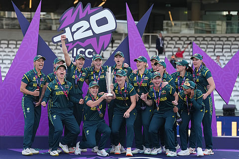 The Australia team celebrate on the podium with the trophy after winning the Women's T20 Cricket World Cup final between England and Australia in London.
