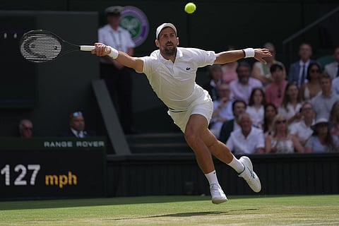 Novak Djokovic of Serbia returns the ball to Roman Saffiulin of Russia in their fourth round men's singles match at the Wimbledon Tennis Championships in London.