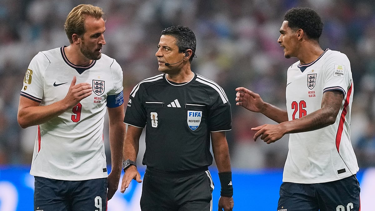 Referee Alireza Faghani of Australia talks with England's Harry Kane (9) and Jarell Quansah (26) after Quansah was given a red card during the World Cup round of 16 soccer match between Mexico and England in Mexico City, Sunday, July 5, 2026 - (AP Photo/Natacha Pisarenko )