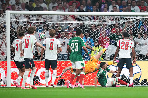 A shot by Mexico's Julian Quinones, not visible, enters the net of England goalkeeper Jordan Pickford for Mexico's first goal during the World Cup round of 16 soccer match between Mexico and England in Mexico City, Sunday, July 5, 202
