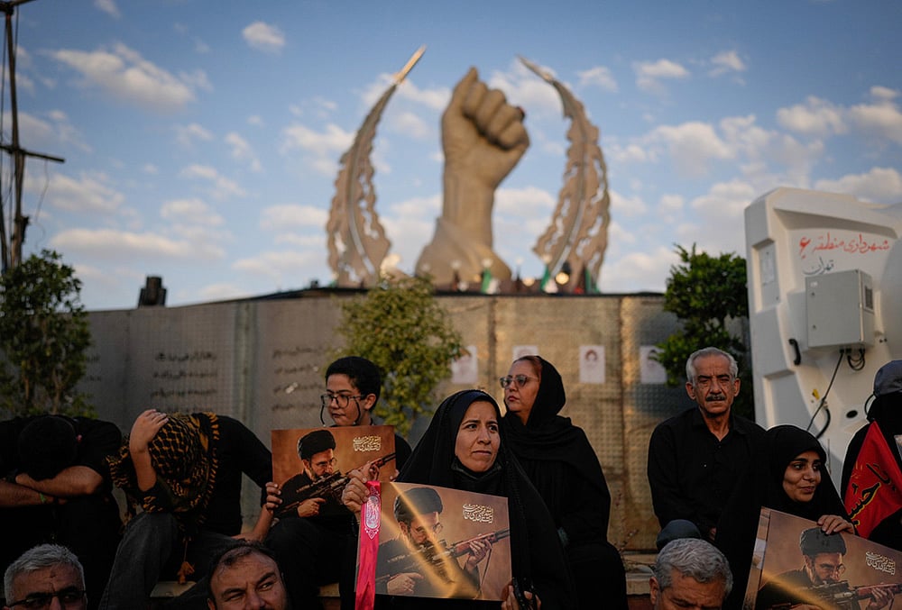 Mourners hold portraits of Irans new Supreme Leader Mojtaba Khamenei