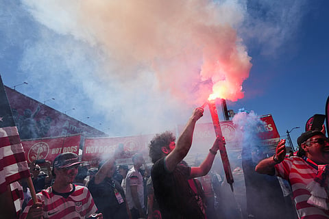 Fans light flares as they arrive at the stadium ahead of the World Cup round of 16 soccer match between the United States and Belgium in Seattle, Monday, July 6, 2026.