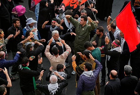 Mourners chant and perform mourning rituals as they make their way to the funeral procession of the slain Iranian Supreme Leader Ayatollah Ali Khamenei in Tehran, Iran, Monday, July 6, 2026.