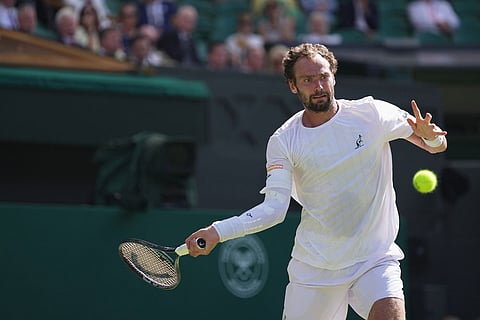 Roman Saffiulin of Russia returns the ball to Novak Djokovic of Serbia in their fourth round men's singles match at the Wimbledon Tennis Championships in London.