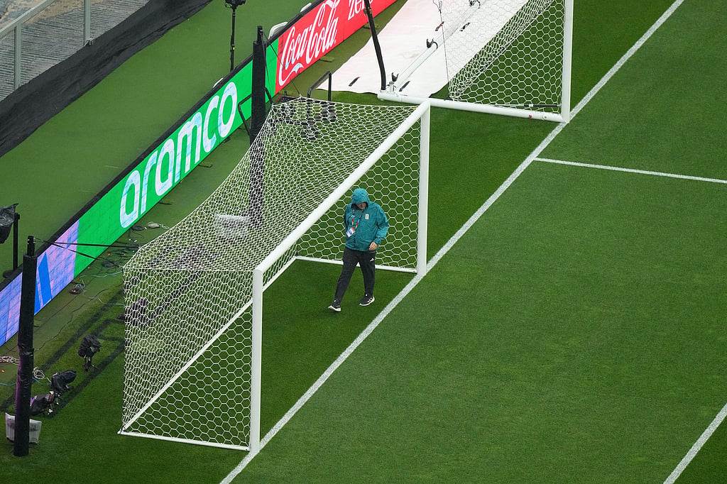 An official walks on the field as the game between Mexico and England is delayed due to weather for the World Cup round of 16 soccer match in Mexico City