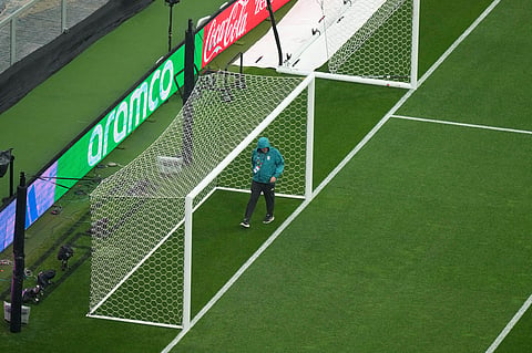 An official walks on the field as the game between Mexico and England is delayed due to weather for the World Cup round of 16 soccer match in Mexico City
