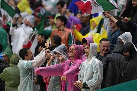 Mexico fans on the stands wait in the rain for the start of the World Cup round of 16 soccer match between Mexico and England in Mexico City, Sunday, July 5, 2026