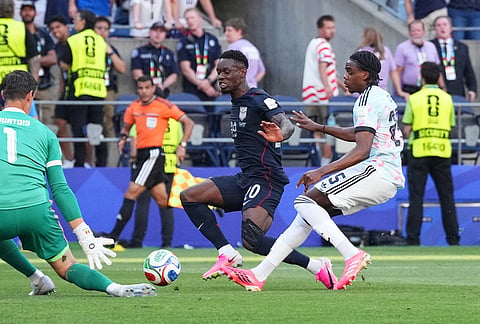 United States' Folarin Balogun (20) tries to score on Belgium goalkeeper Thibaut Courtois (1) during the World Cup round of 16 soccer match in Seattle, Monday, July 6, 2026.