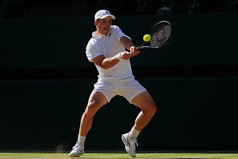 Arthur Fery of Britain plays a return during the men's singles fourth round match against Grigor Dimitrov of Bulgaria at the Wimbledon Tennis Championships in London.