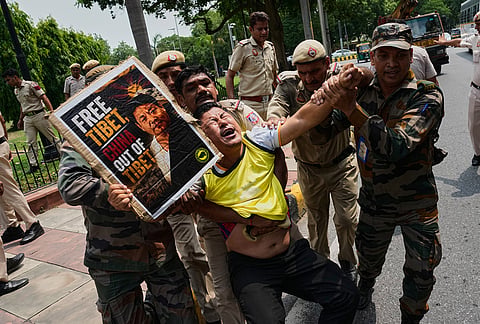Policemen detain an exiled Tibetan protester outside the Chinese Embassy in New Delhi, India, during a demonstration against political repression in Tibet.