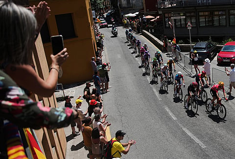 A woman takes photos of the riders during the third stage of the Tour de France cycling race with start in Granollers and finish in Les Angles, France, Monday, July 6, 2026. 