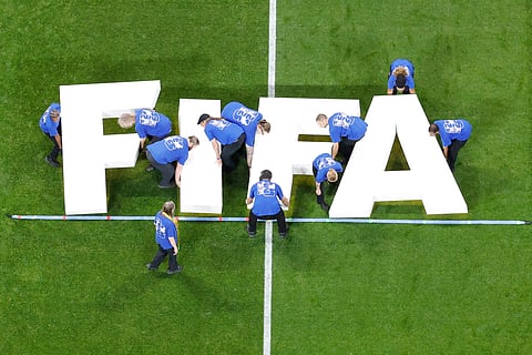 Fifa staff place a Fifa logo on the pitch before the World Cup round of 16 soccer match between Argentina and Egypt in Atlanta, Tuesday, July 7, 2026.