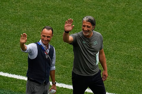Switzerland head coach Murat Yakin, right, waves on the pitch before their World Cup round of 16 soccer match against Colombia in Vancouver, British Columbia
