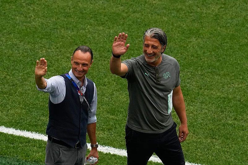 Switzerland head coach Murat Yakin, right, waves on the pitch before their World Cup round of 16 soccer match against Colombia in Vancouver, British Columbia