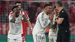 Real Madrid's Kylian Mbappe, center, and Vinicius Jr., left, disagree with referee Slavko Vincic during the Champions League quarterfinal second leg soccer match between Bayern Munich and Real Madrid in Munich, Germany. - | Photo: AP/Matthias Schrader