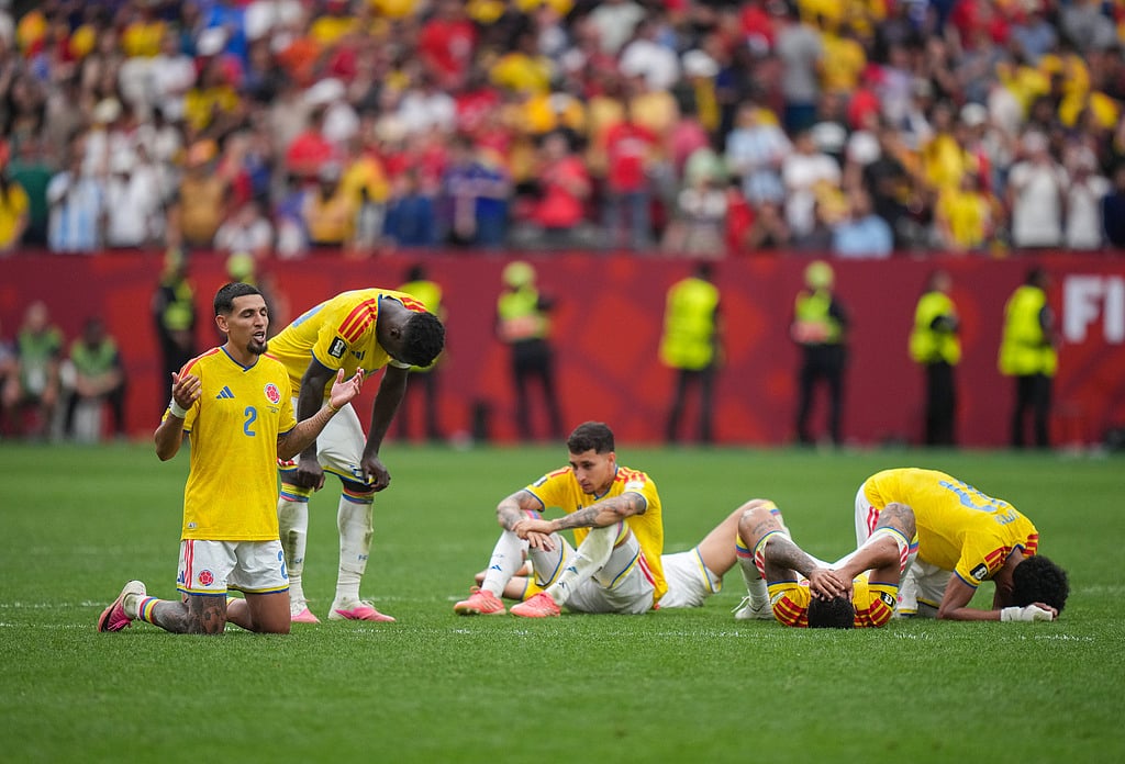 Colombias Daniel Munoz (2) kneels on the field with his collapsed teammates after losing to Switzerland in a penalty kick shootout in the World Cup round of 16 soccer match between Switzerland and Colombia in Vancouver, British Columbia