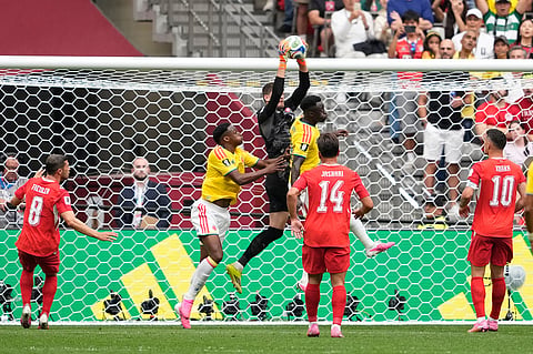 Switzerland's Gregor Kobel, center, grabs the ball during the World Cup round of 16 soccer match between Switzerland and Colombia in Vancouver, British Columbia