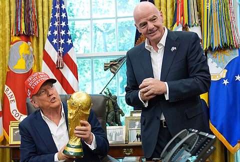 US President Donald Trump holds the FIFA World Cup Winners Trophy as FIFA President Gianni Infantino looks on during an announcement in the Oval Office of the White House, Aug. 22, 2025, in Washington. 