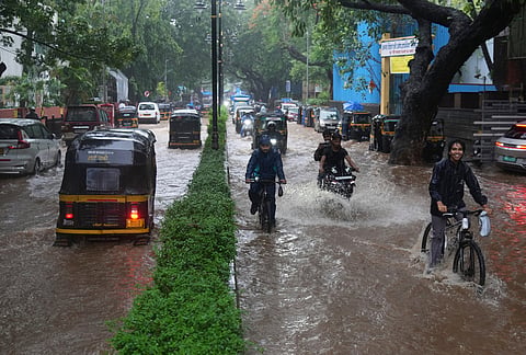 Vehicles drive through a waterlogged street during monsoon rains in Mumbai, India. Wednesday, July 1, 2026. 