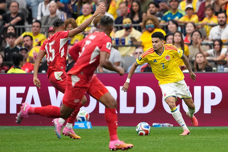 Colombias Luis Díaz (7) controls the ball against Switzerlands Djibril Sow (15) and Manuel Akanji (5) during the World Cup round of 16 soccer match between Switzerland and Colombia in Vancouver