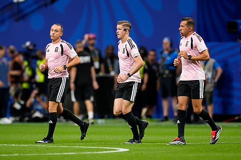 Referee Francois Letexier, center, of France, and his assistants warm up before the World Cup round of 16 soccer match between Argentina and Egypt in Atlanta, Tuesday, July 7, 2026.